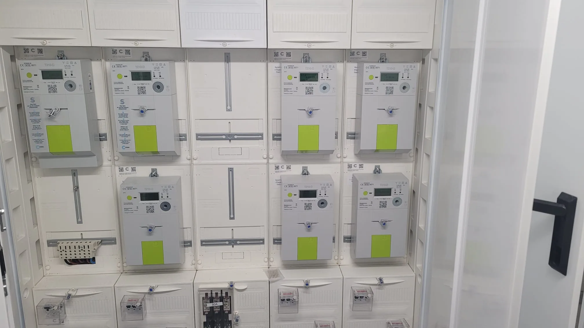 Colonne de comptage d'immeuble — sept compteurs communicants Creos alignés dans une armoire collective