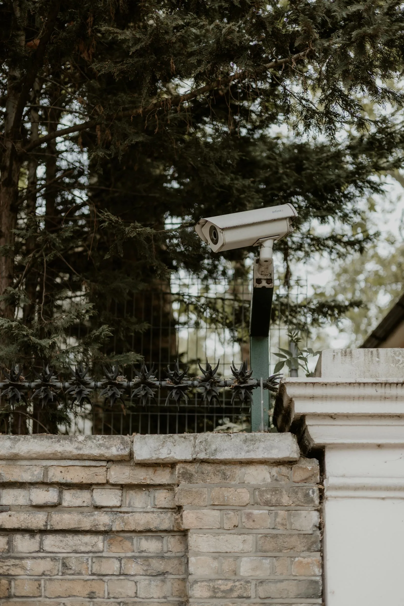 Caméra extérieure de surveillance sur mur de briques d'une maison — protection périmètre et jardin